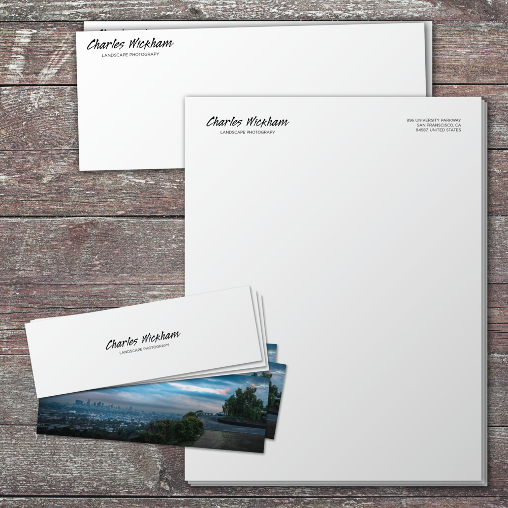 Business envelopes and cards for Charles Wickham Landscape Photography on a wooden surface.